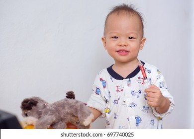 Portrait Of Cute Smiling Little Asian 18 Months / 1 Year Old Toddler Baby Boy Child Who Having Flu Feeding Himself With Liquid Medicine With A Syringe, Fever Cold And Flu Concepts