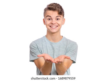 Portrait Of Cute Smiling Teen Boy Holding Nothing. Happy Teenager With Empty Palms Up, Isolated Over White Background. Child Stretched Out His Hands - Sign Of Begging Or Giving.