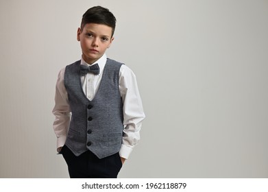 Portrait Of Cute Teen Boy In Suit With Bow Tie On White Background