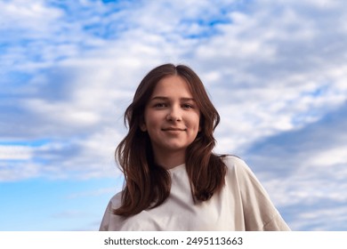 Portrait of cute teen girl with dimples in white jacket at blue sky background, smile looking at camera. Face of teenage hipster lady 13 year old outdoor. Youth gen z style concept. Copy ad text space - Powered by Shutterstock