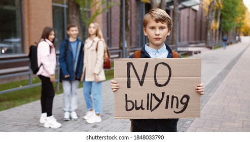 Portrait Of Cute Teen Schoolboy Standing Outdoors With 