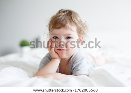 Similar – Little girl smiling lying over the bed