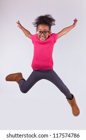 Portrait Of Cute Young African American Girl Jumping, Over Gray Background