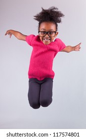 Portrait Of Cute Young African American Girl Jumping, Over Gray Background