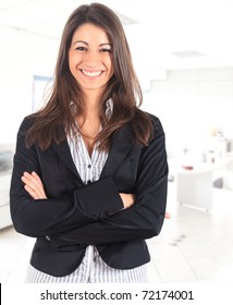 Portrait Of A Cute Young Business Woman Smiling, In An Office Environment