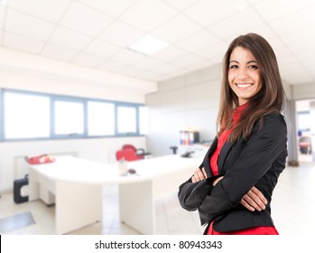 Portrait Of A Cute Young Business Woman Smiling, In An Office Environment