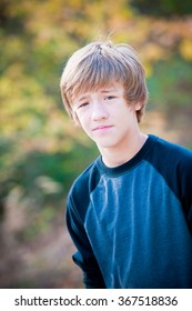 Portrait Of Cute Young Teen Looking At Camera With Not Much Expression On Face.