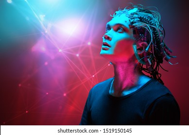 Portrait of a cyborg looking up over red background. Biological human robot with wires implanted in the head. Technologies of the future. Copy space.