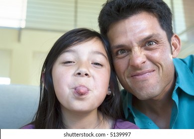 Portrait Of A Dad And Daughter Making Silly Faces