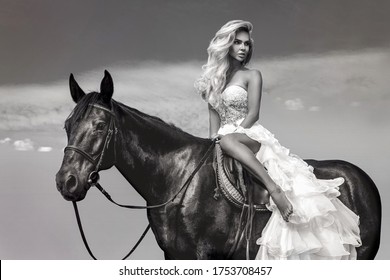 Portrait of a dark horse and woman. Beautiful glamour woman with a horse. Portrait of a beauty blonde bride in wedding dress with horse. Black and white photo.