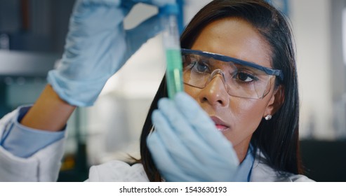 Portrait Of Dark Skin Female Scientist Is Analyzing A Liquid To Extract The DNA And Molecules In The Test Tubes In Laboratory. 