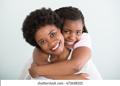 Portrait Of A Daughter Embracing Her Mother From Behind Against White Background