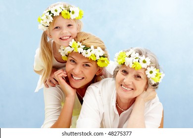 Portrait Of Daughter Over Her Mother And Grandmother With Flowers On Their Heads