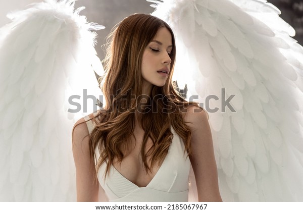 Portrait of\
delicate, sensual woman as an angel with white wings. Girl with\
long healthy hair and glamour makeup.\
