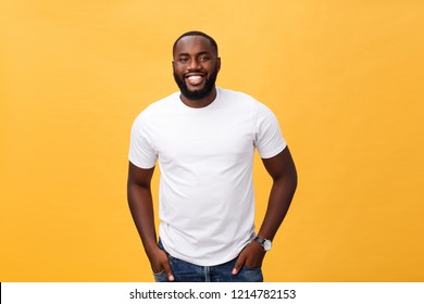 Portrait of delighted African American male with positive smile, white perfect teeth, looks happily at camera, being successful enterpreneur, wears white t shirt.