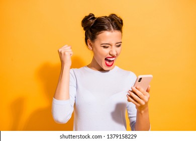 Portrait of delighted thrilled excited screaming lady impressed by news feed in her social network account rasing fists isolated on vibrant background in white clothing - Shutterstock ID 1379158229