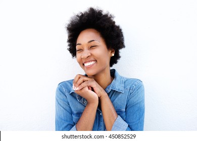 Portrait of delighted woman smiling by white wall
