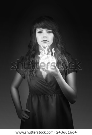 Portrait of a demon woman holding a ball of fire in black and white