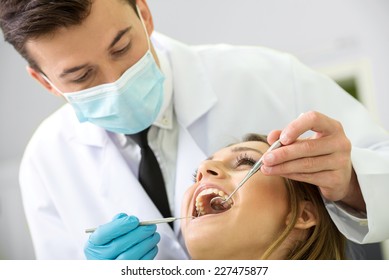 Portrait Of A Dentist Who Treats Teeth Of Young Woman Patient.