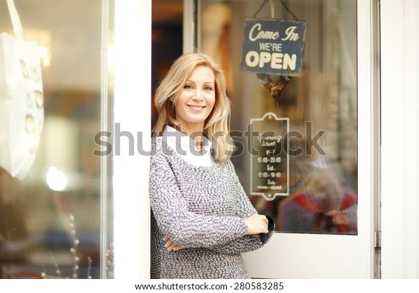 Portrait of designer woman standing in front of\
small vintage store. Small\
business.
