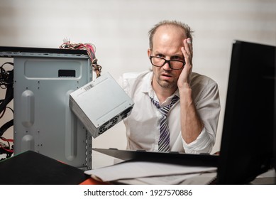 Portrait Of Desperate Office Worker Trying To Fix Broken Computer