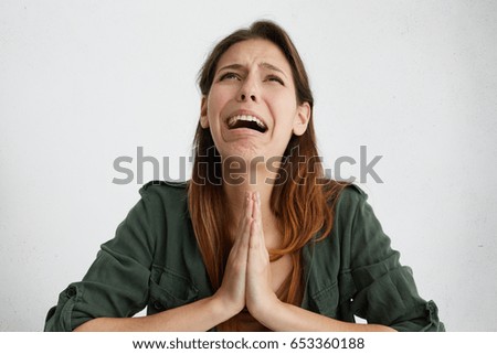 Portrait of desperate woman begging for mercy and crying. Emotional woman holding her palms together looking griveous while begging for something. Crying disappointed female asking for forgiveness