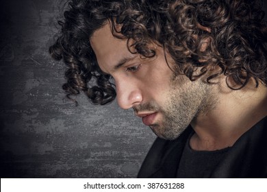 Portrait of desperate young attractive man with curly hair
