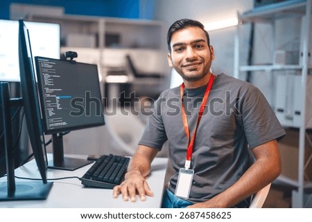 Portrait of developer programming IT technology career. Young adult indian programmer coding typing keyboard in modern office. Productivity data coder software development. Overtime work employee