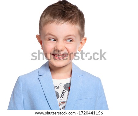 Portrait of a devious child, a devilish smile. A funny grimace, a child making faces. On white background.