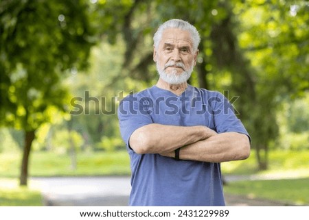 Portrait of a dignified, bearded senior man with a strong stance in a serene, green park setting, evoking wisdom and wellness. Stock photo © 