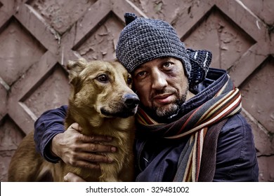 Portrait of dirty tramp hugging his dog. Image with toning and selective focus
