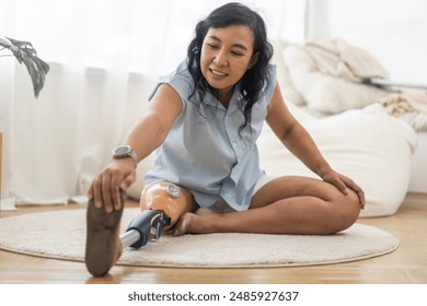 Portrait of disabled asian woman with prosthetic leg sitting at home, feeling hopeful, happy, new life, not discouraged, leg, disability, care, prosthetic equipment, walking doing physical exercise - Powered by Shutterstock