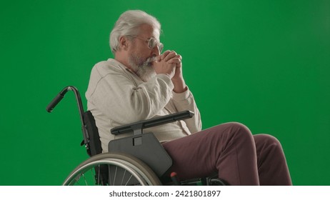 Portrait of disabled man isolated on chroma key green screen close up. Senior man sitting in wheelchair thinking, holding hands crossed. - Powered by Shutterstock