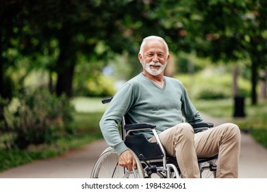 Portrait of disabled mature man, smiling for the camera, in the park. - Powered by Shutterstock