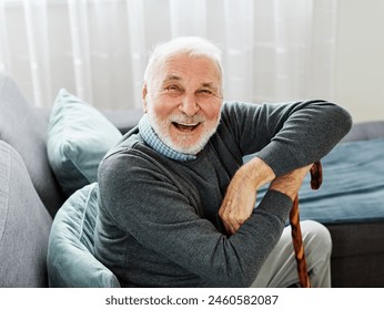 Portrait of a disabled senior man  with a walking cane stick  at home - Powered by Shutterstock