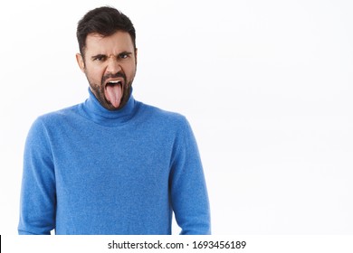 Portrait Of Disgusted And Displeased Grimacing Funny Bearded Man, Showing Tongue And Frowning Bothered, See Something Awful, Taste Bad Cooked Food, Standing Disappointed White Background