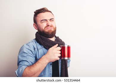 Portrait of disgusted man tasting something from cup