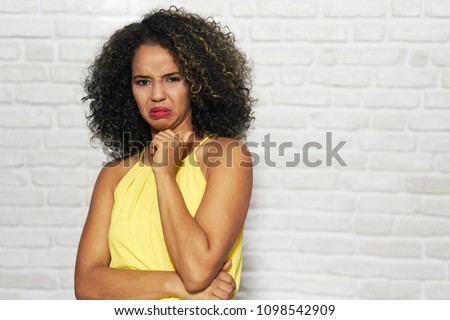 Portrait of disgusted woman, hispanic girl showing disgust for bad smell or taste.