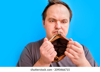 Portrait Of Disheveled Adult Man Shaving Stubble With Electric Razor, Blue Studio Background