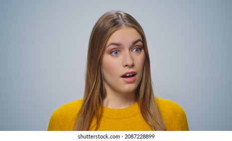Portrait displeased woman gesturing hands on grey background in studio. Closeup disappointed customer looking camera. Upset female model shock in slow motion. Shocked girl negative emotion