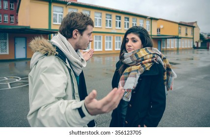 Portrait Of Dissapointed Woman Listening Arguments Of Young Man During A Hard Quarrel Outdoors. Couple Relationships And Problems Concept.