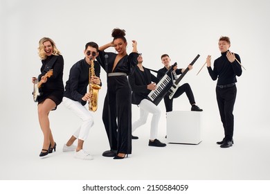 Portrait of diverse group of young people musical band playing with instruments - isolated on white background. - Shutterstock ID 2150584059