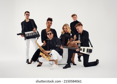 Portrait of diverse group of young people musical band playing with instruments - isolated on white background. - Powered by Shutterstock