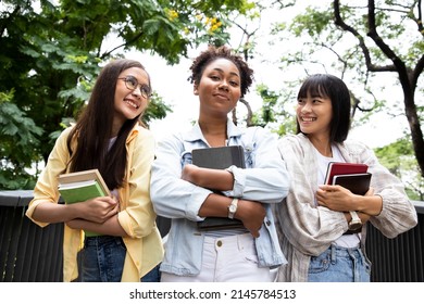 Portrait Of A Diversity Woman Student Holding Books And Looking At Natural Outdoors With Friends At Park. Prepare For College And University Concept