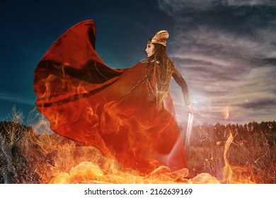 Portrait Of Divine Female Warrior Valkyrie In Red Cape Fighting In A Battle With A Sword In Her Hand Surrounded By Burning Fire. Epic Fantasy. Scandinavian Mythology. 