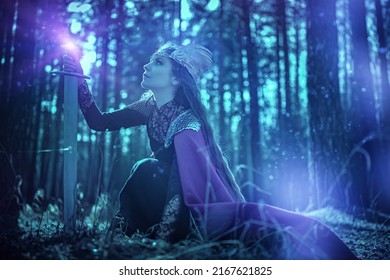 Portrait Of A Divine Female Warrior Valkyrie In A Dark Dense Forest Holding A Magic Sword. Scandinavian Mythology. Fantasy. 