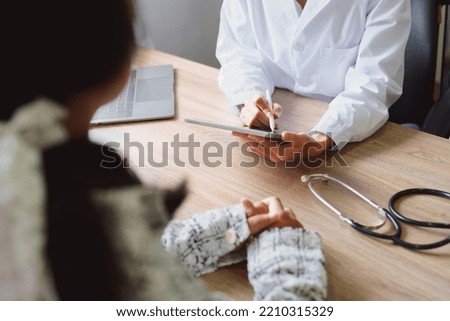 Portrait of a doctor advising clients on health issues holding a tablet to work and talking to patients who come to treatment.