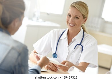 Portrait of doctor giving prescription to patient