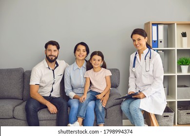 Portrait of a doctor and a happy family are looking at the camera in the clinic office.