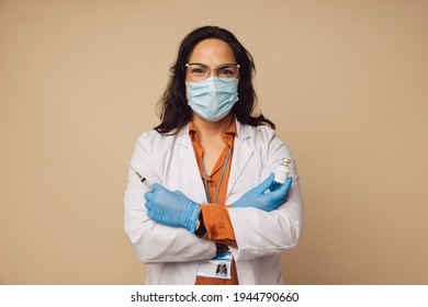 Portrait Of Doctor Holding A Syringe And Covid-19 Vaccine Vial. General Practitioner Ready For Vaccinating.